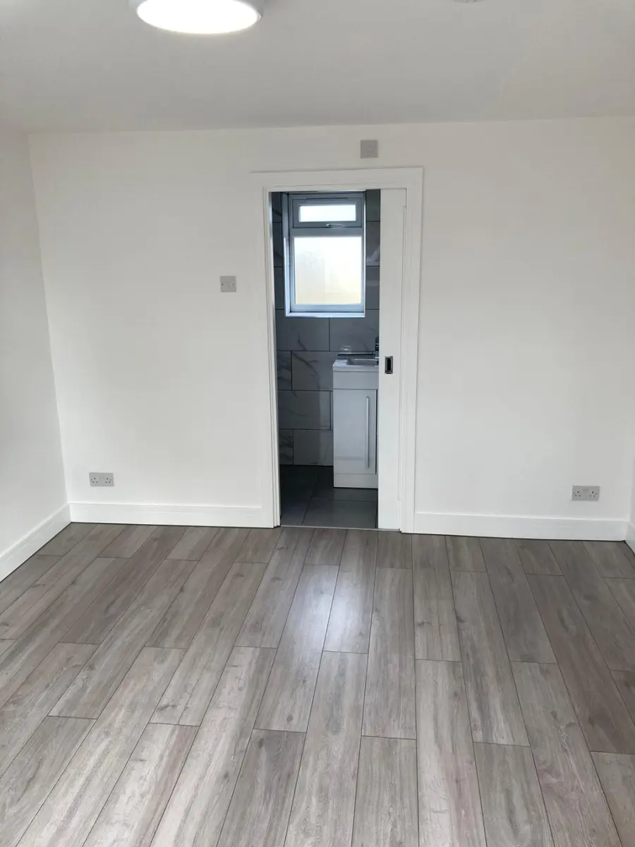 Finished bright room with white walls and grey flooring