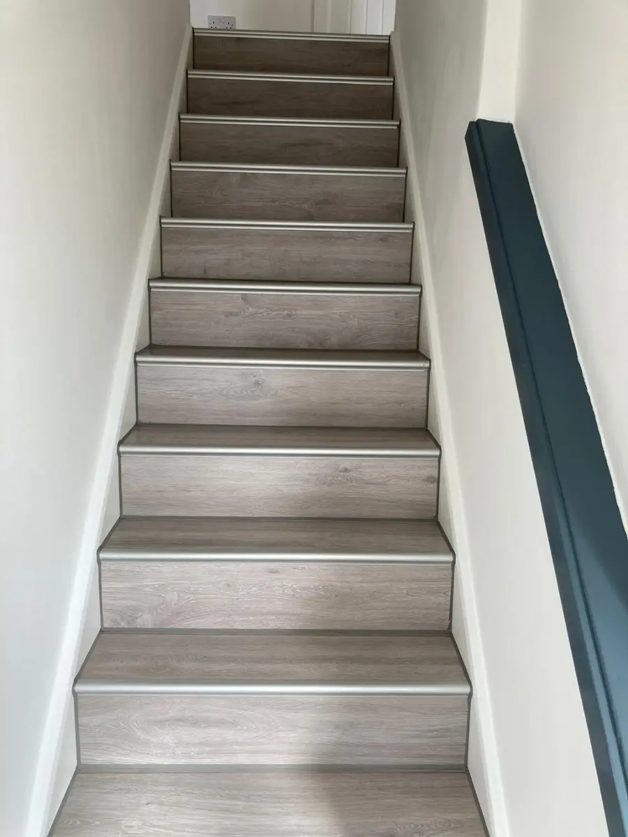 Completed staircase with grey finish and dark handrail